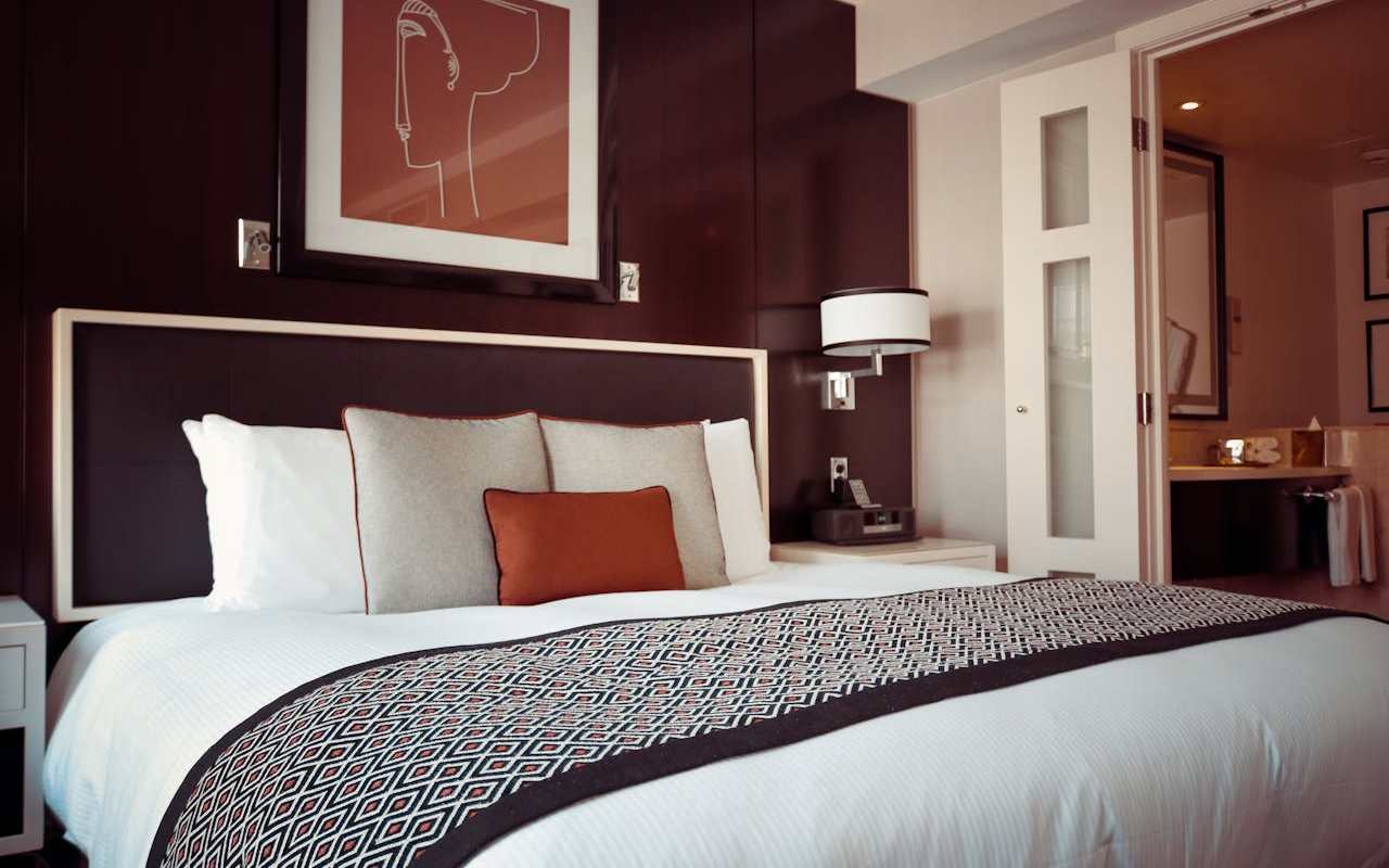 <br />
Hotelska soba sa velikim krevetom na kom se nalaze jastuci.<br />
